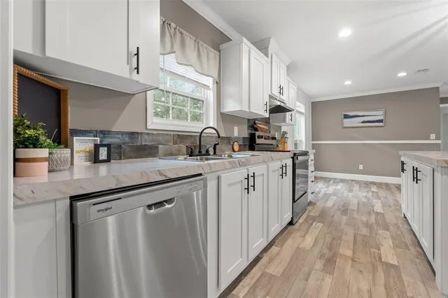 a kitchen with stainless steel appliances granite countertop a sink stove and cabinets