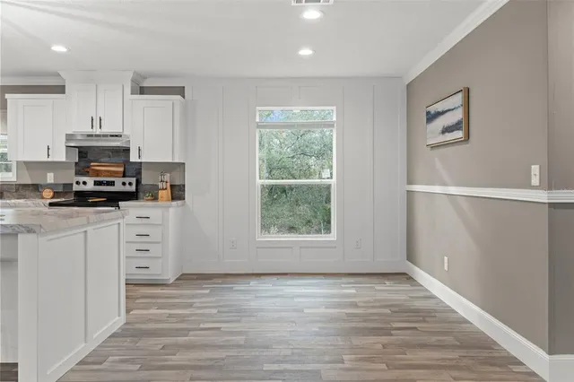 a view of kitchen appliances wooden floor and window
