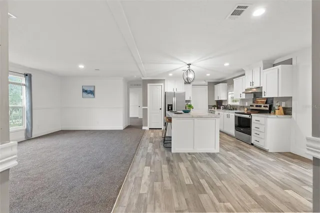 a view of kitchen with wooden floor and electronic appliances