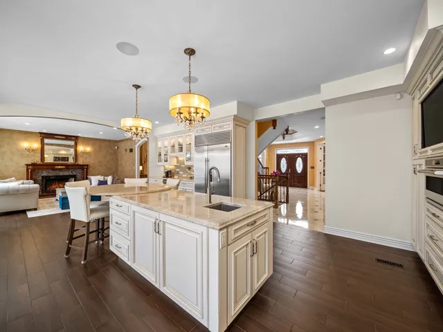 a kitchen with a dining table chairs wooden floor and appliances
