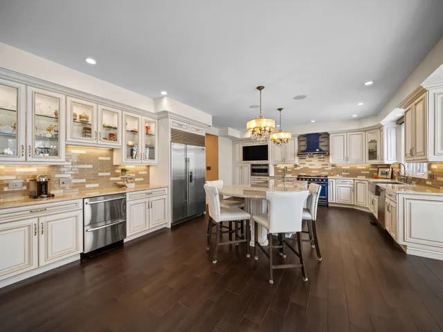 a view of a dining room and livingroom with furniture wooden floor a chandelier