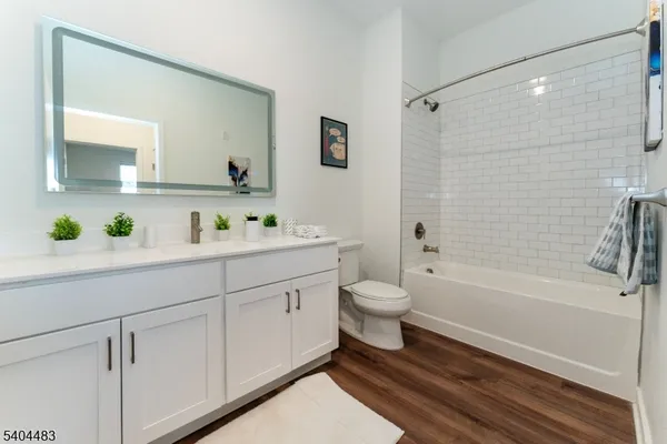 a bathroom with a bathtub shower sink vanity and toilet