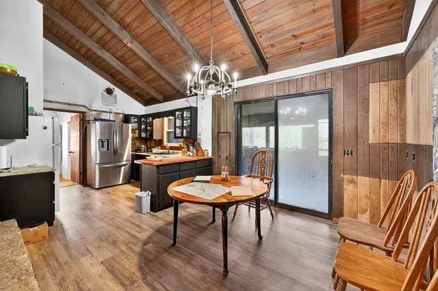 a view of a dining room with furniture a chandelier and wooden floor