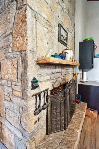 an empty room with wooden floor and fireplace