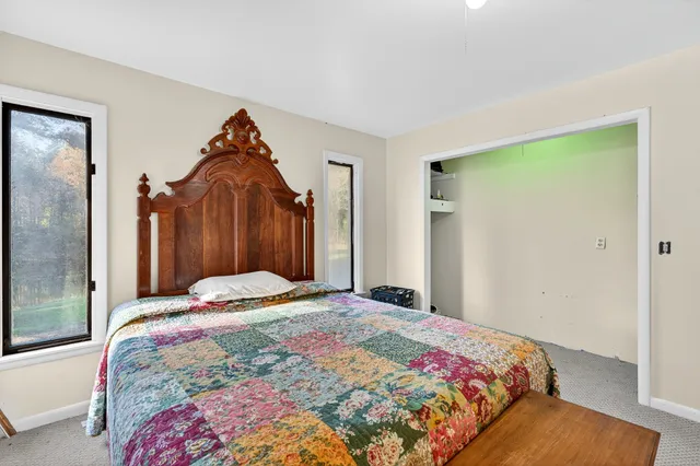 a bed sitting in a bedroom next to a window