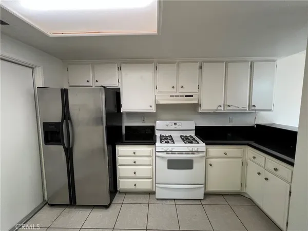 a kitchen with white cabinets stainless steel appliances and a sink
