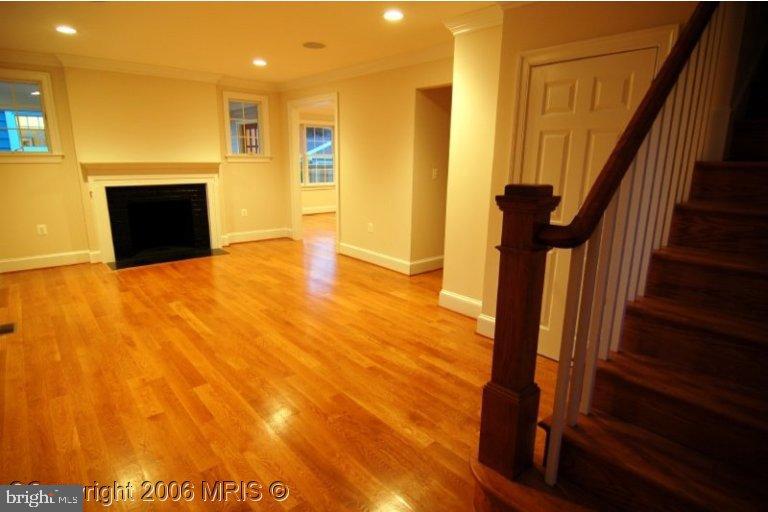 4416 Ridge Street Chevy Chase, MD 20815 - Photo 6 of 20 a view of an empty room with wooden floor and a fireplace