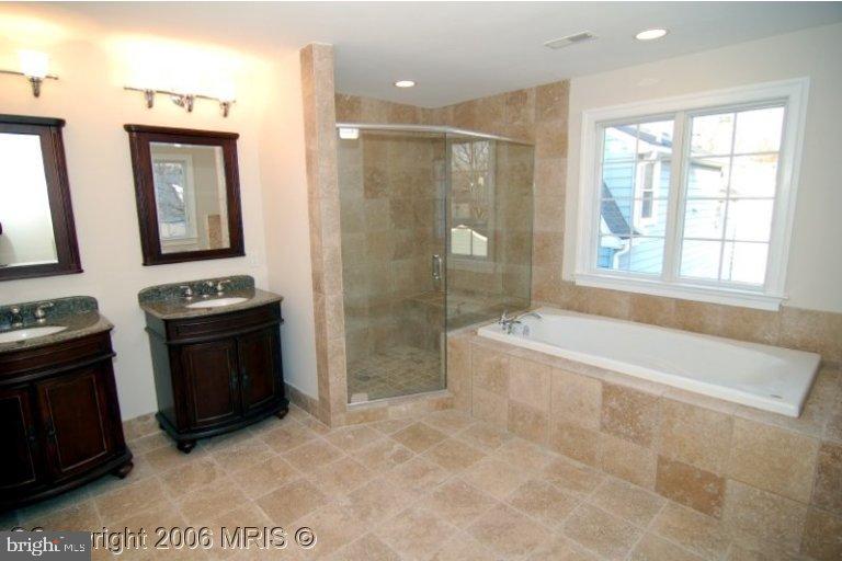 4416 Ridge Street Chevy Chase, MD 20815 - Photo 8 of 20 a bathroom with a granite countertop sink a mirror a bathtub and next to a window