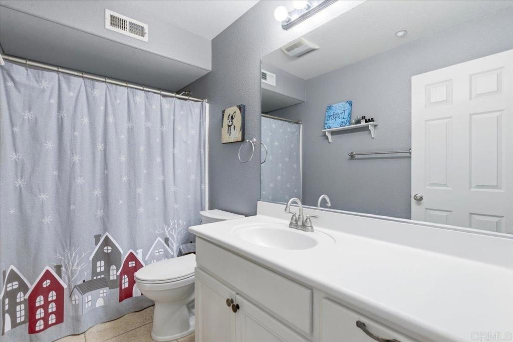 1101 Goddard Street San Marcos, CA 92078 - Photo 28 of 38 a bathroom with a sink a toilet and shower curtain