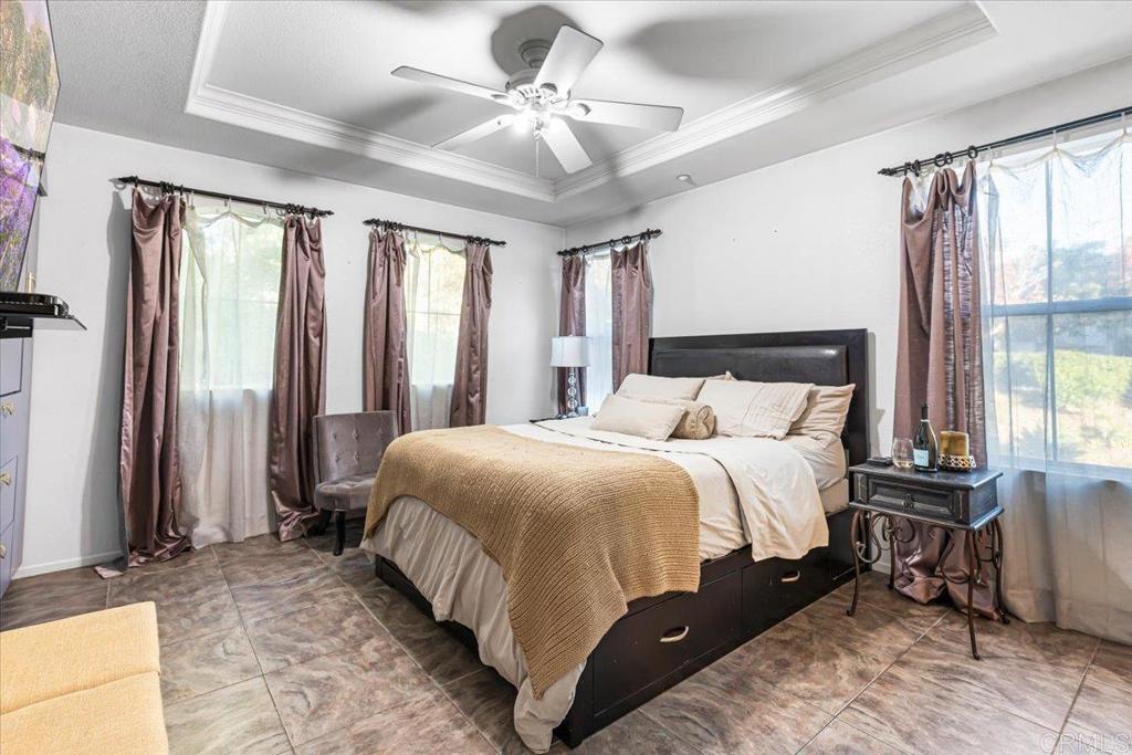 1101 Goddard Street San Marcos, CA 92078 - Photo 30 of 38 a bedroom with a large bed and a chandelier