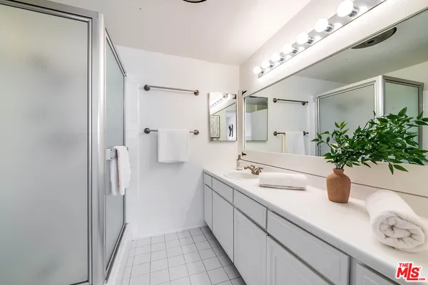 a bathroom with a double vanity sink mirror and shower