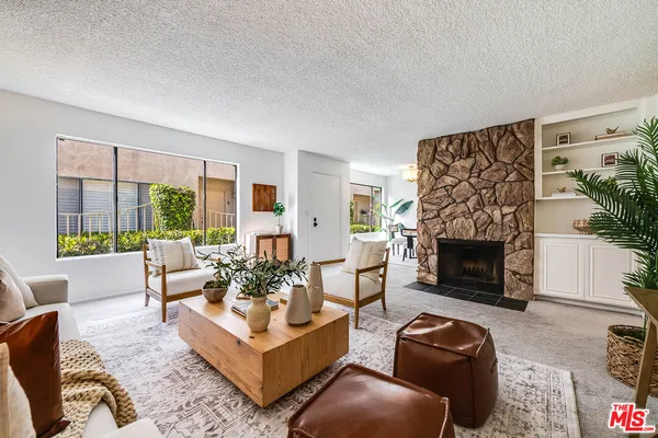 a living room with furniture a large window and a fireplace