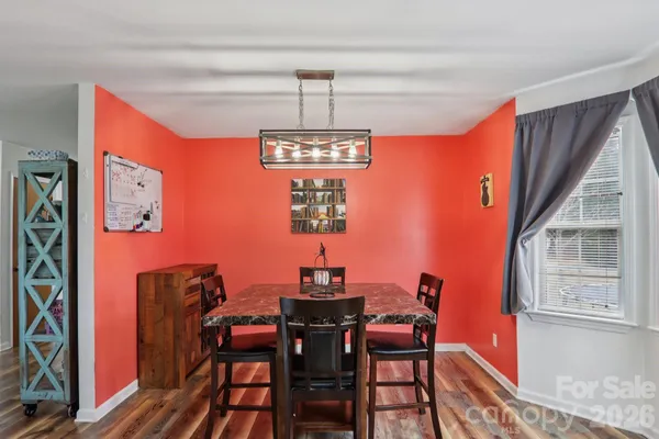 a dining room with furniture a chandelier and wooden floor
