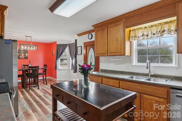 a kitchen with stainless steel appliances granite countertop a sink a stove and a wooden cabinets