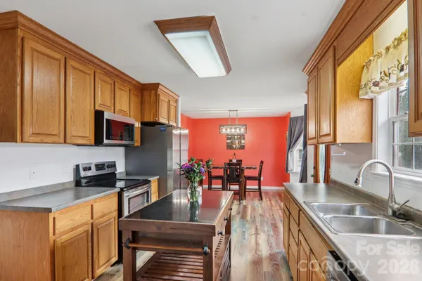 a kitchen with granite countertop a sink a counter top space and stainless steel appliances