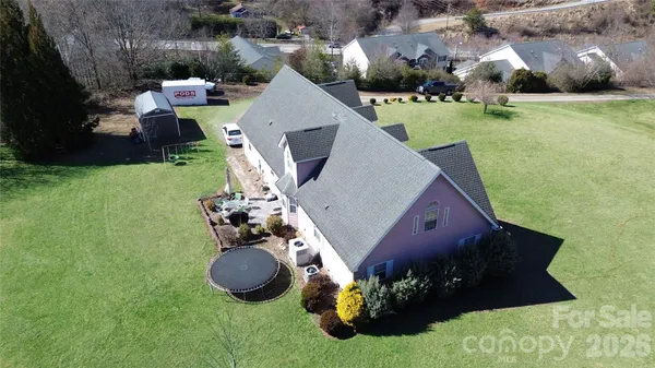 an aerial view of a house with yard and mountain view in back