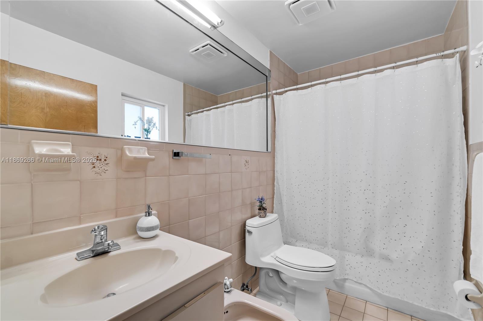 980 West 43rd Place, Unit 980 Hialeah, FL 33012 - Photo 11 of 17 a bathroom with a sink a toilet and shower curtain