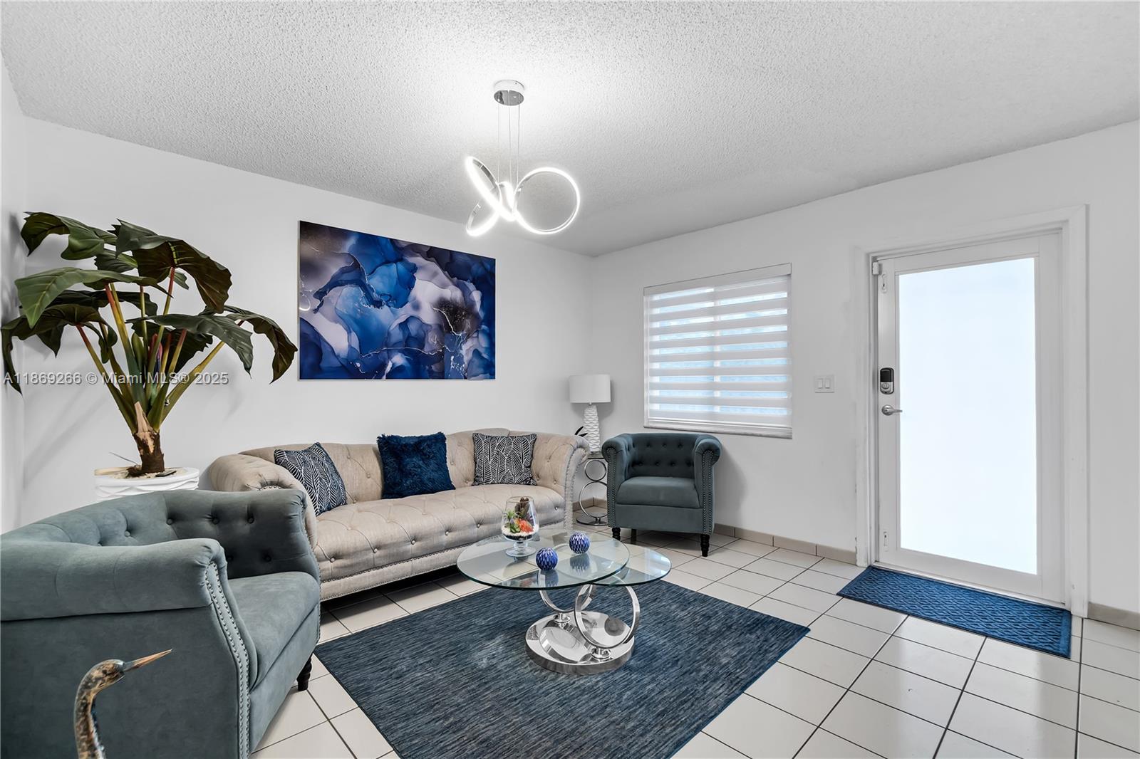 980 West 43rd Place, Unit 980 Hialeah, FL 33012 - Photo 2 of 17 a living room with furniture a rug and a window