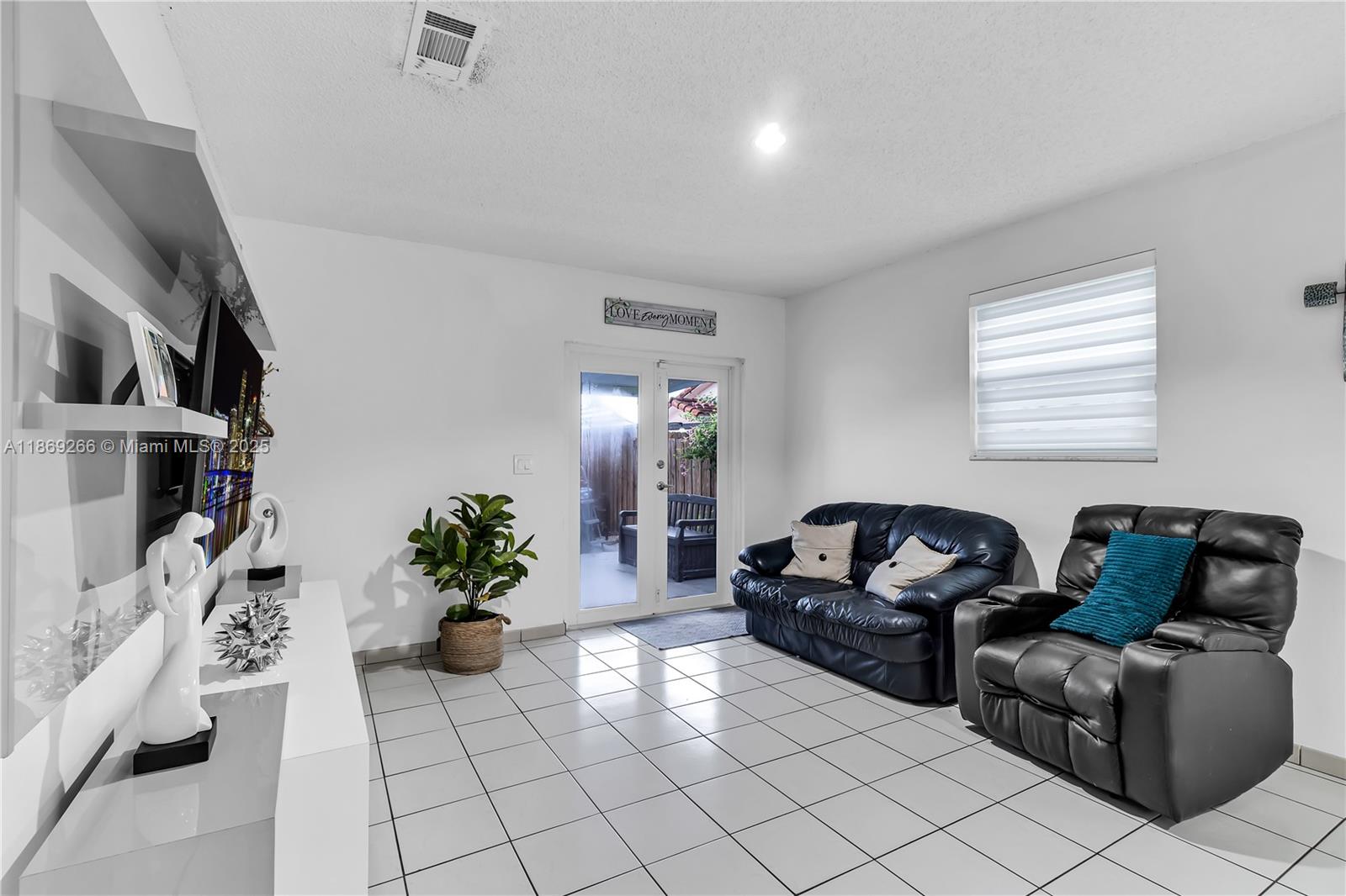 980 West 43rd Place, Unit 980 Hialeah, FL 33012 - Photo 4 of 17 a living room with furniture flowerpot and flower pot
