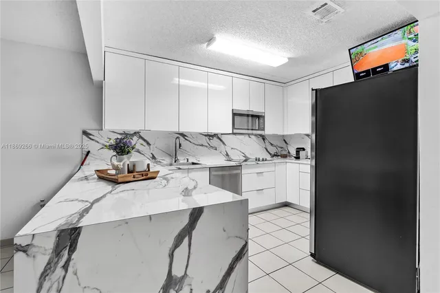 a kitchen with stainless steel appliances a refrigerator sink and cabinets