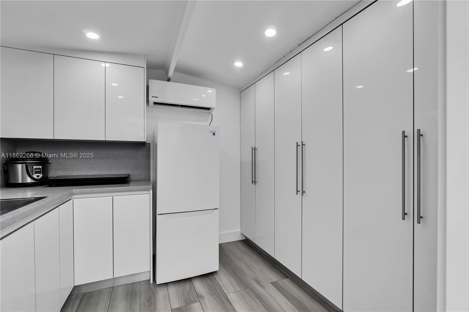 980 West 43rd Place, Unit 980 Hialeah, FL 33012 - Photo 7 of 17 a kitchen with cabinets and a wooden floor