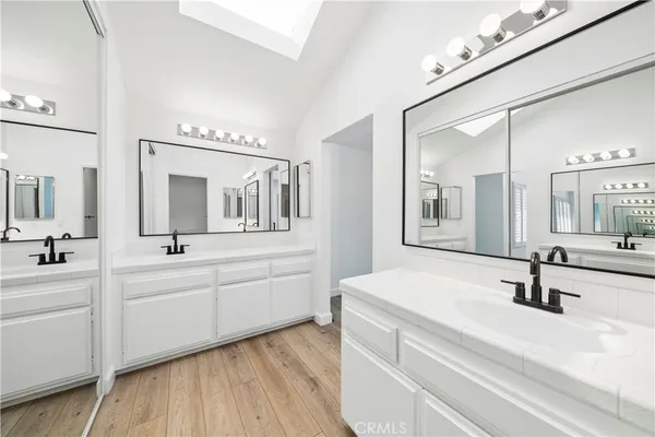 a bathroom with double vanity sinks and a mirror
