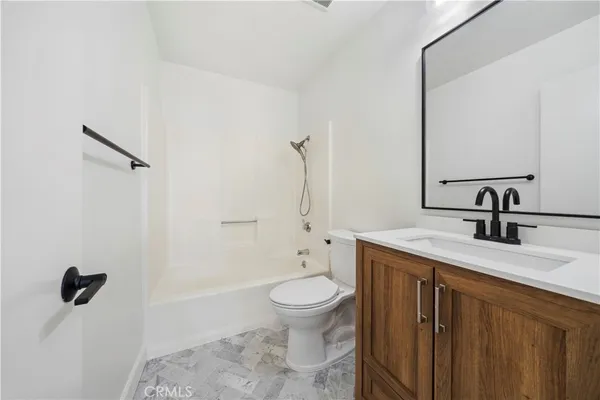 a bathroom with a granite countertop sink a toilet and a mirror