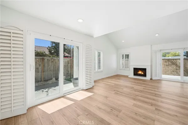a view of empty room with wooden floor and fireplace
