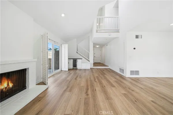 a view of empty room with wooden floor and fireplace