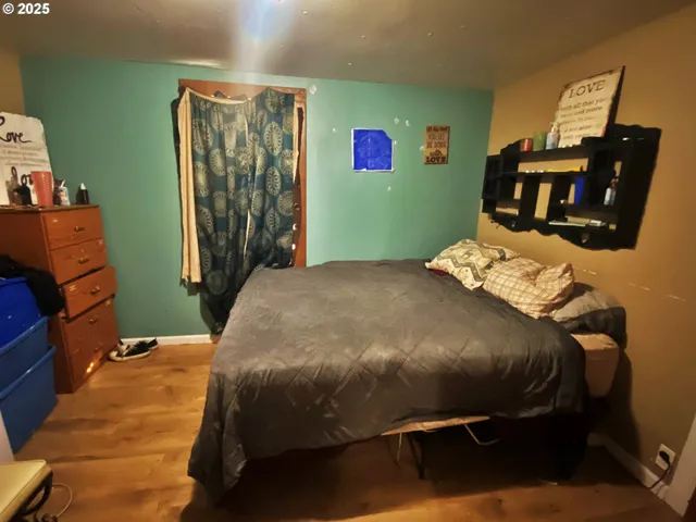 a bedroom with a bed and wooden floor