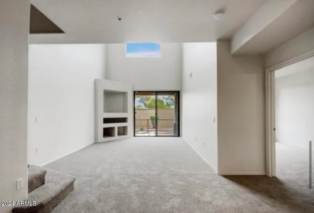a view of an empty room with a fireplace and a window