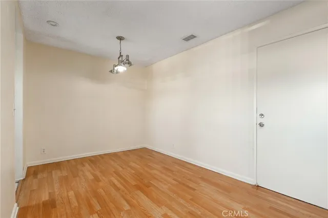 a view of a room with wooden floor and white walls