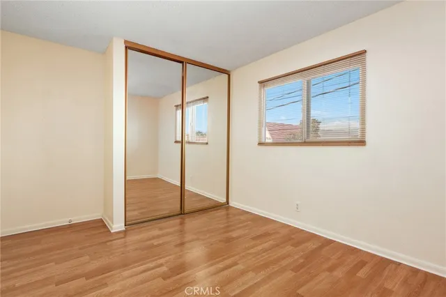 an empty room with wooden floor and a window