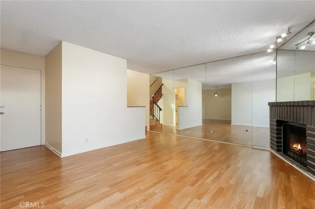 a view of empty room with wooden floor and fireplace