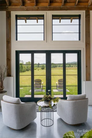 a living room with furniture and floor to ceiling windows