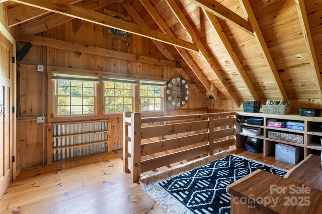 a view of stairs and an empty room with wooden floor
