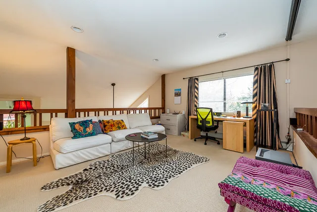 a living room with furniture a rug and white walls