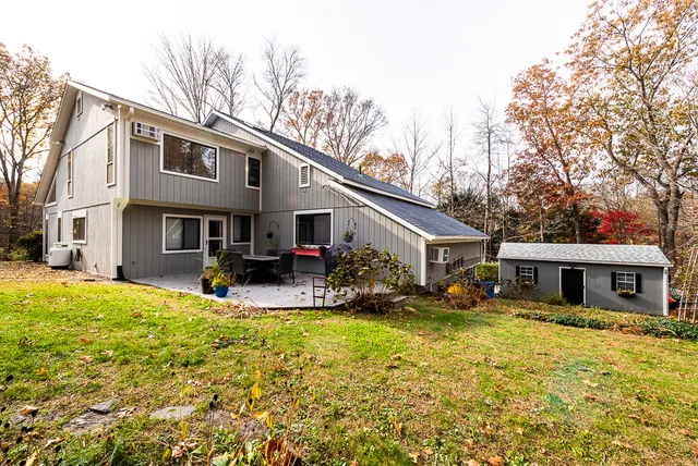 a view of a house with a yard patio and fire pit