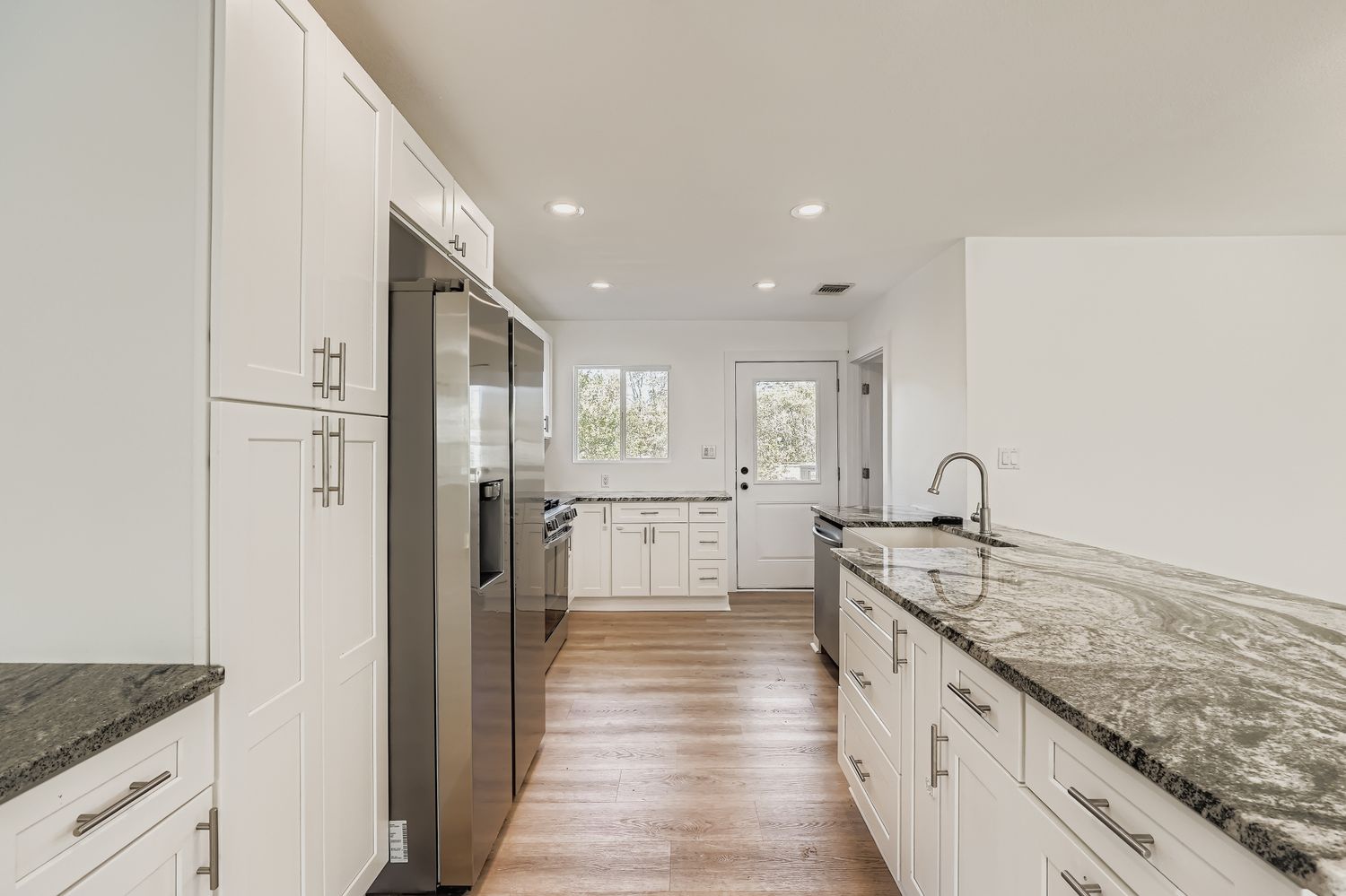 112 Tenorio Street Kyle, TX 78640 - Photo 4 of 11 a large kitchen with stainless steel appliances granite countertop a lot of counter space and wooden floor