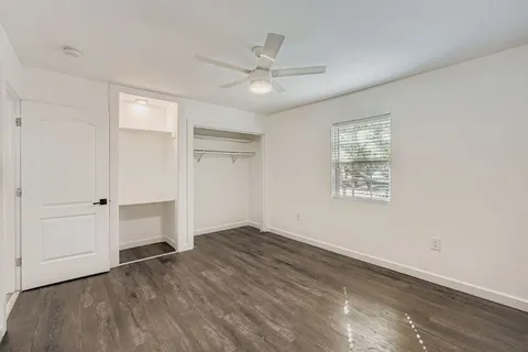 an empty room with closet and windows