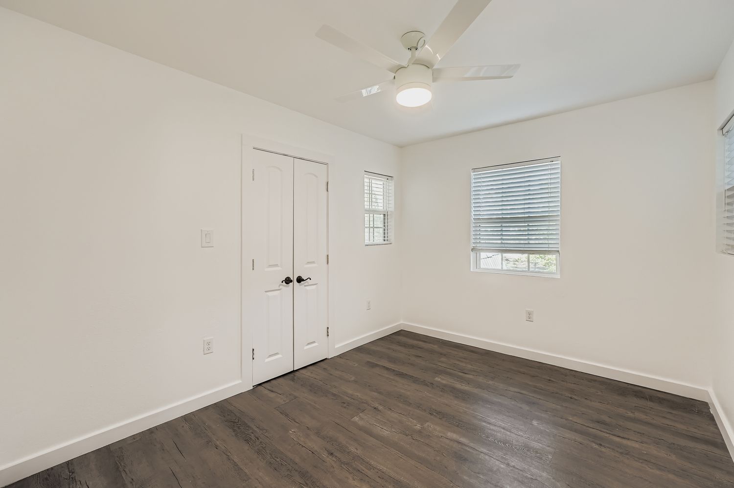 112 Tenorio Street Kyle, TX 78640 - Photo 7 of 11 an empty room with wooden floor fan and windows