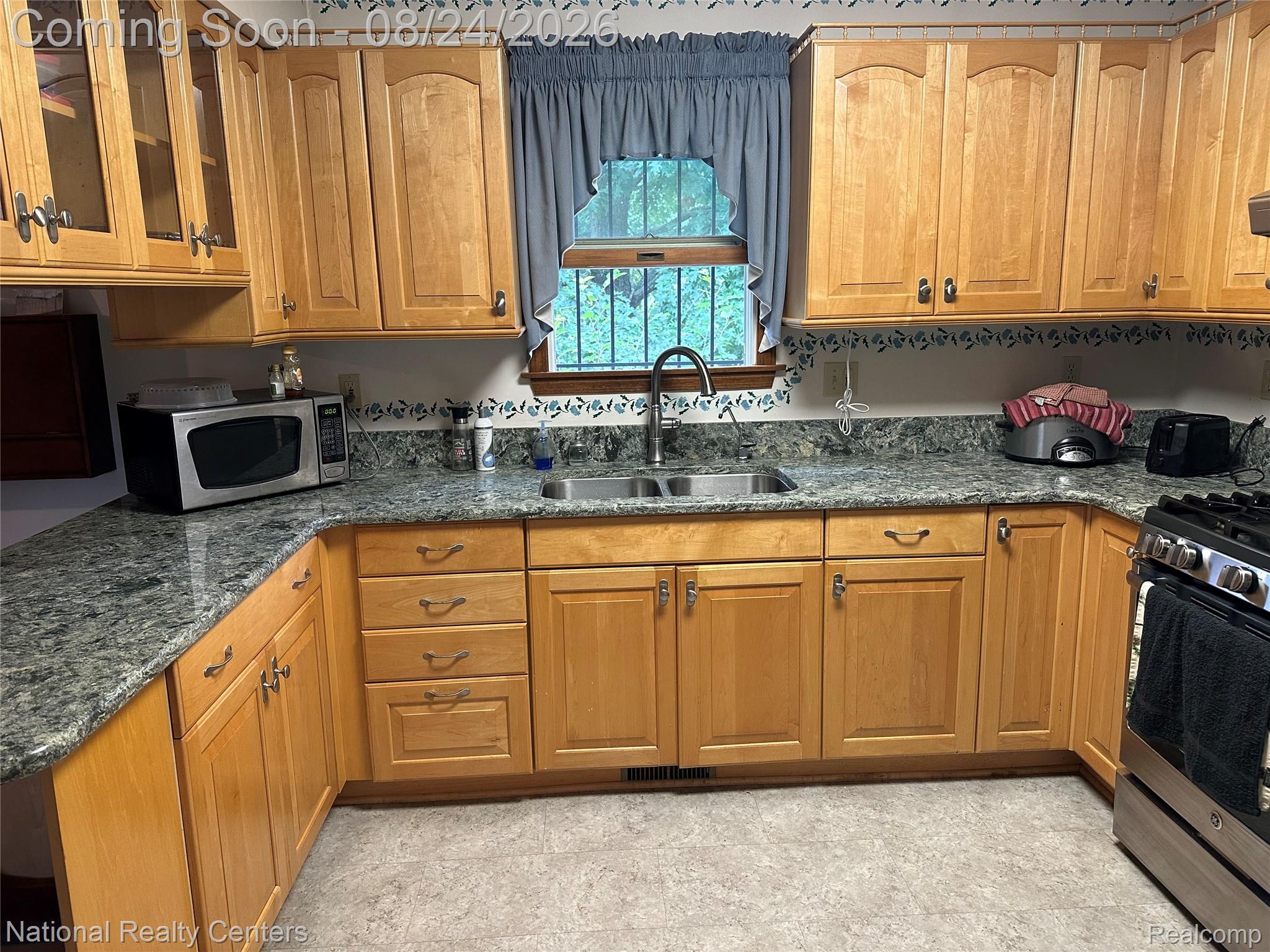 968 Tyrrell Road Bancroft, MI 48414 - Photo 8 of 24 U-shaped kitchen with light wood cabinetry, stone-finish countertops, stainless steel sink, and a stainless steel range
