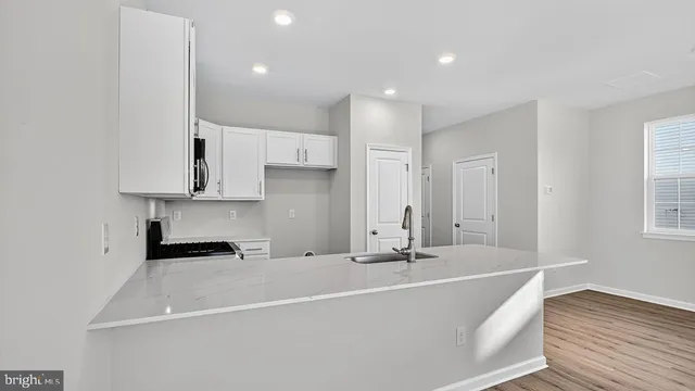 a large white kitchen with a refrigerator and white cabinets