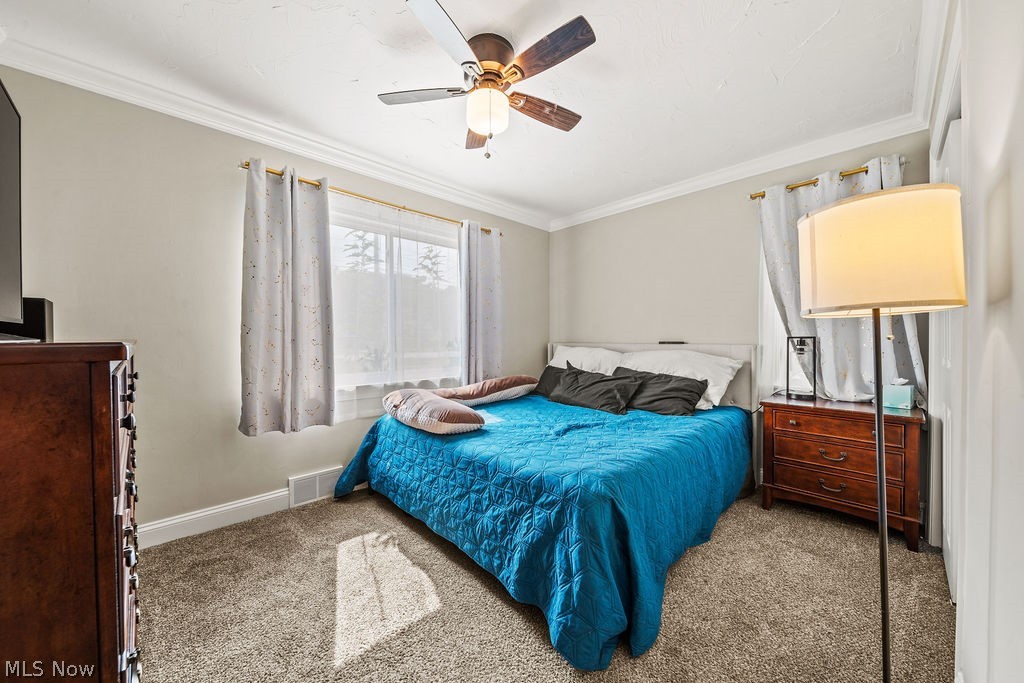 6366 Engle Road Brook Park, OH 44142 - Photo 26 of 38 Carpeted bedroom with ornamental molding and ceiling fan