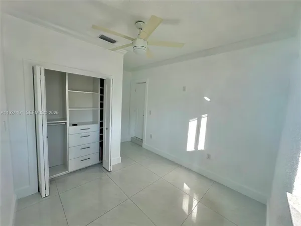 an empty room with windows and closet