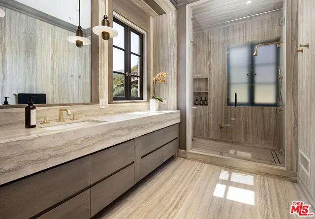 a bathroom with a granite countertop sink mirror and shower