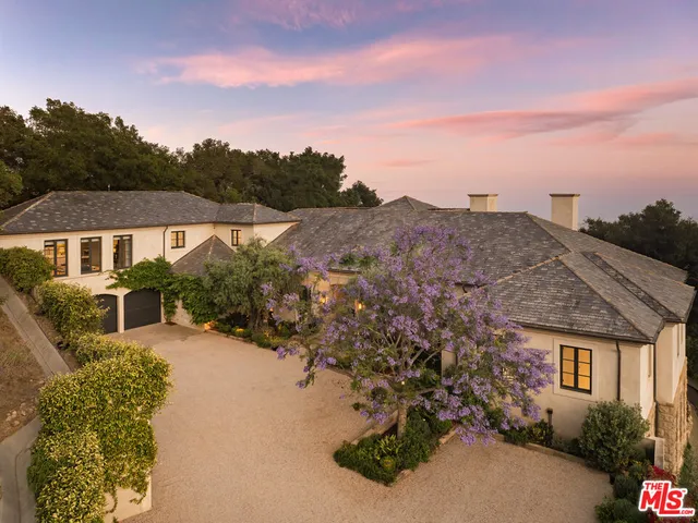an aerial view of house with yard and mountain view in back