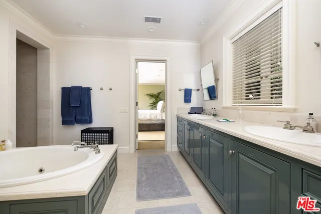 a spacious bathroom with a double vanity sink a mirror and a bathtub