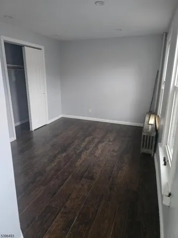 an empty room with wooden floor and a window