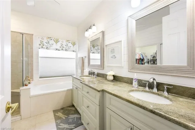 a bathroom with a granite countertop sink mirror and a bathtub